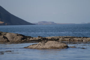A large sea loch. Large rocks in the forground