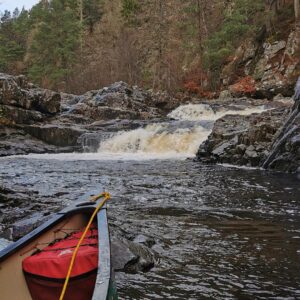 Photo of the Linn of Tummel waterfalls. In the foreground is the front of a canoe