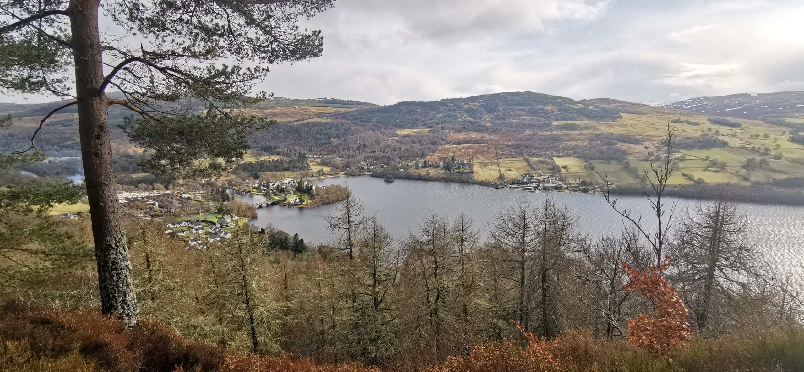 Image of: The view from Black Rock viewpoint, Perthshire. Looking down toward the village of Kenmore with loch Tay cutting through the centre of the image. 